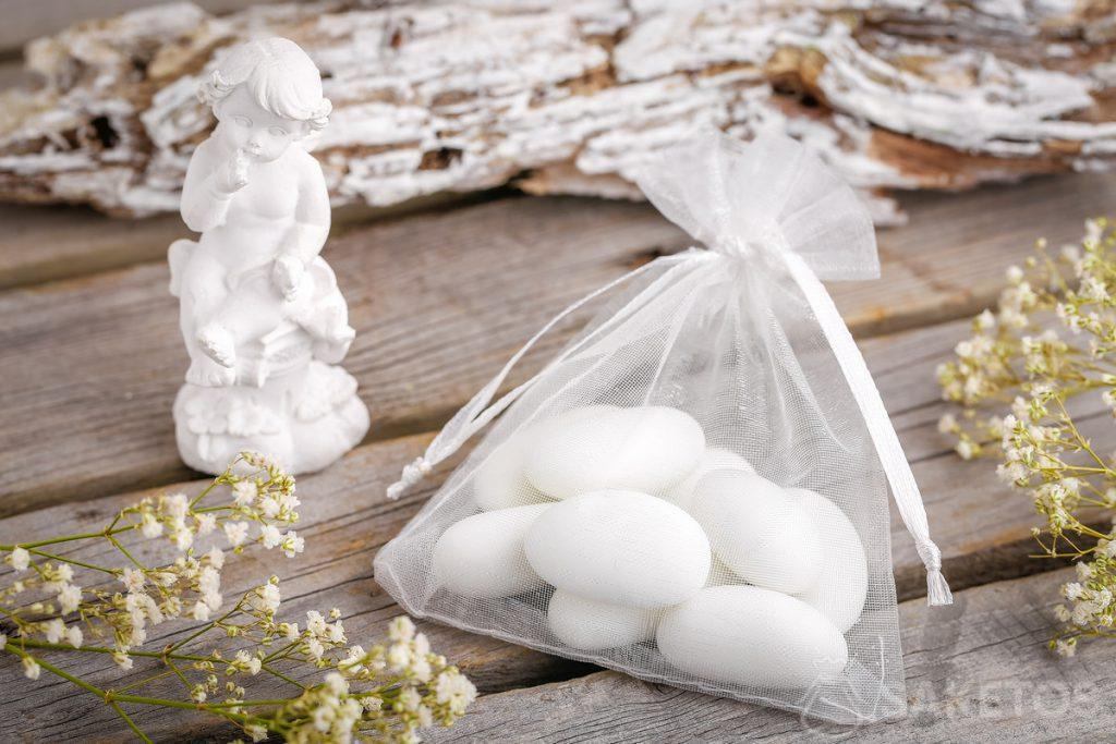 Idee regalo per gli invitati a un matrimonio: confetti o un angioletto confezionati in un sacchetto di organza.