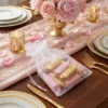 Sacchetti in organza pieni di dolci su una tavola nuziale elegante.