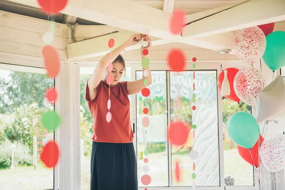 Giovane donna che appende le decorazioni per una festa