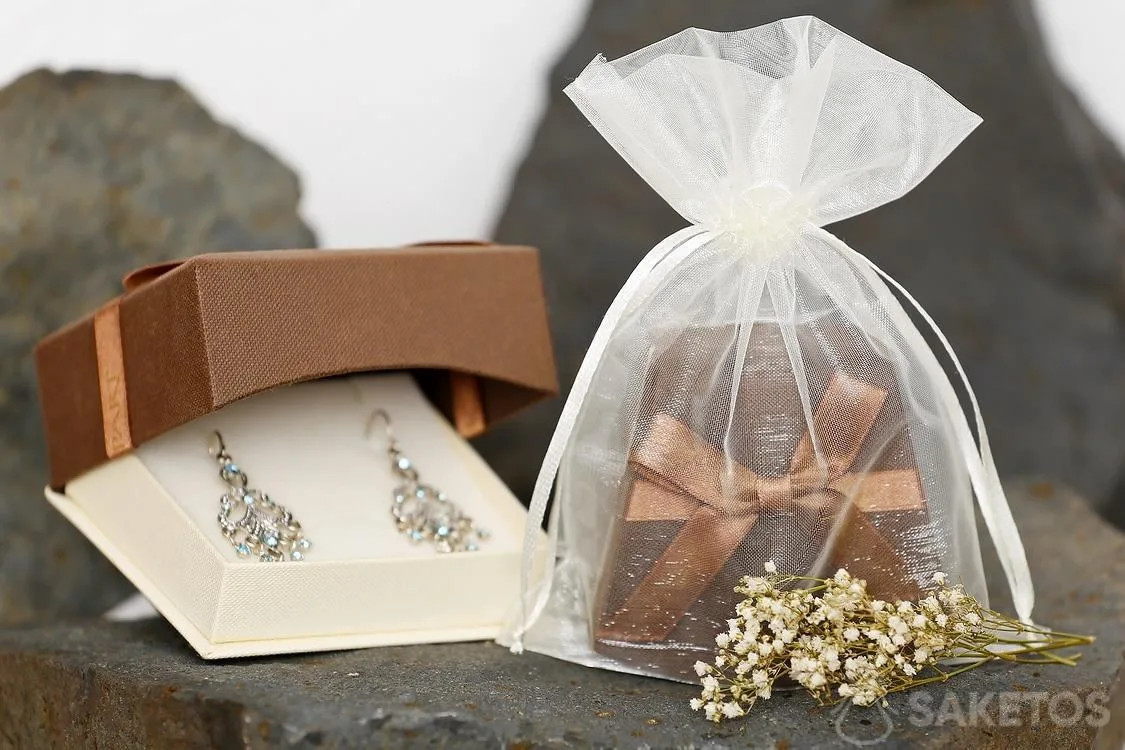 Una scatola regalo con gioielli confezionata in un sacchetto di organza ha un aspetto particolarmente elegante.