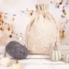 Sacco in lino con coulisse su sfondo decorativo con zucche e gomitolo di lana