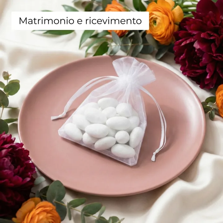 Sacchetto in organza bianco con mandorle su un piatto per bomboniere.